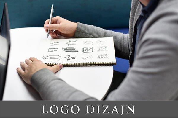dizajner koji u svesci skicira različite logoe